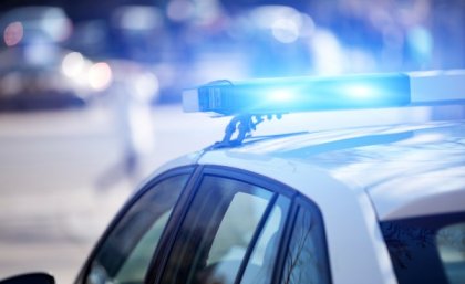 Police car with blue lights in urban setting.